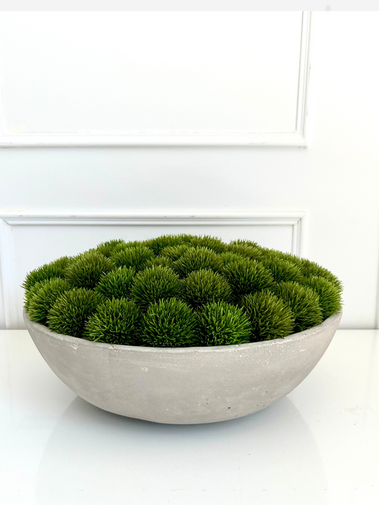 Artificial lush green dianthus set in a large concrete bowl planter.